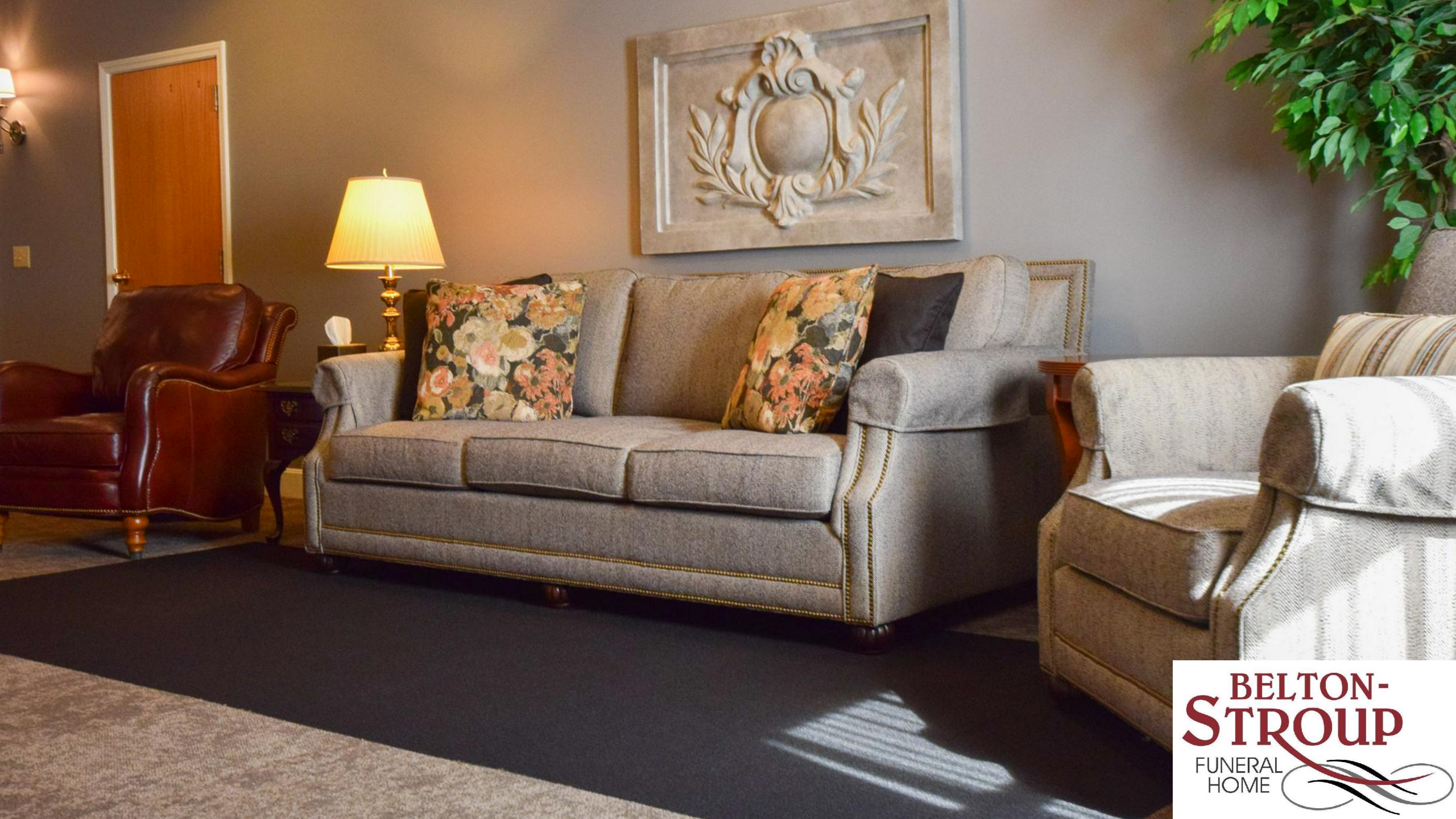 Beige Couch along a wall with natural light coming through an unseen window to the right